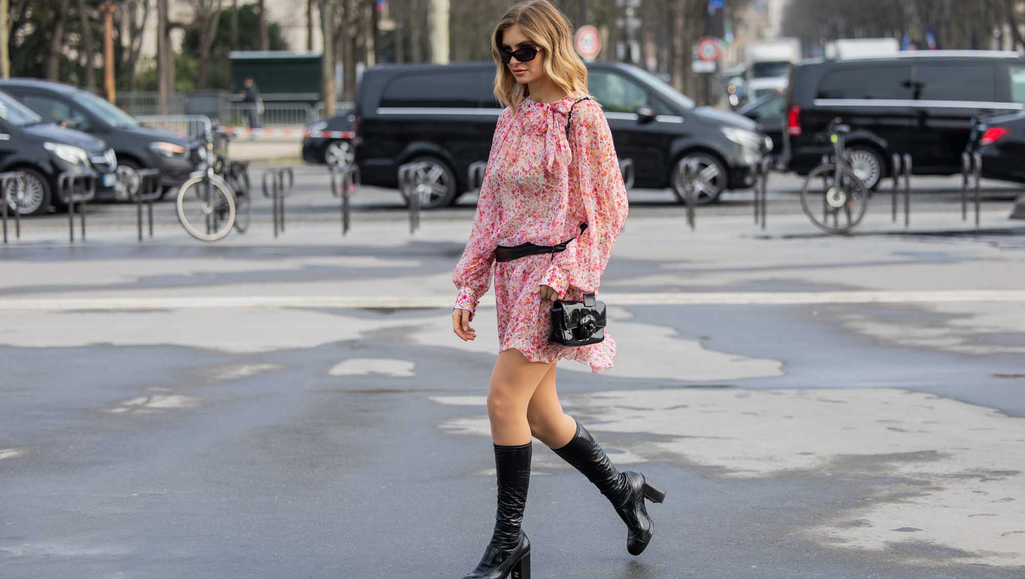 PARIS, FRANCE - MARCH 11: Xenia Adonts wears red white dress with belt, black bag, knee high boots outside Chanel during the Womenswear Fall/Winter 2025/2026 as part of Paris Fashion Week on March 11, 2025 in Paris, France. (Photo by Christian Vierig/Getty Images)