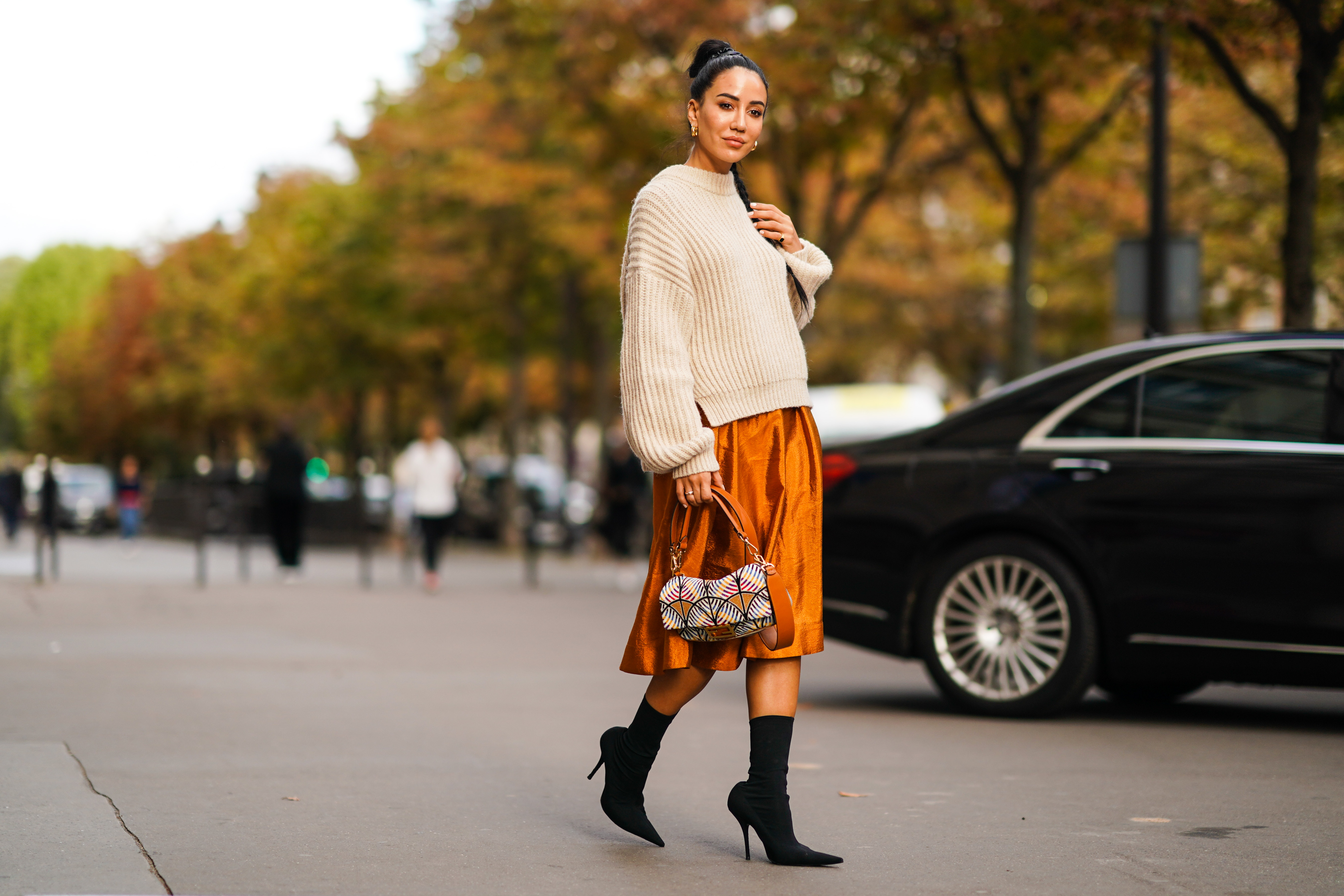 PARIS, FRANCE - SEPTEMBER 28: Tamara Kalinic wears a wool pullover, an orange shiny silky skirt, earrings, a Fendi bag, black high heeled boots, outside CDG Comme des Gar&ccedil;ons, during Paris Fashion Week - Womenswear Spring Summer 2020 on September 28, 2019 in Paris, France. (Photo by Edward Berthelot/Getty Images)