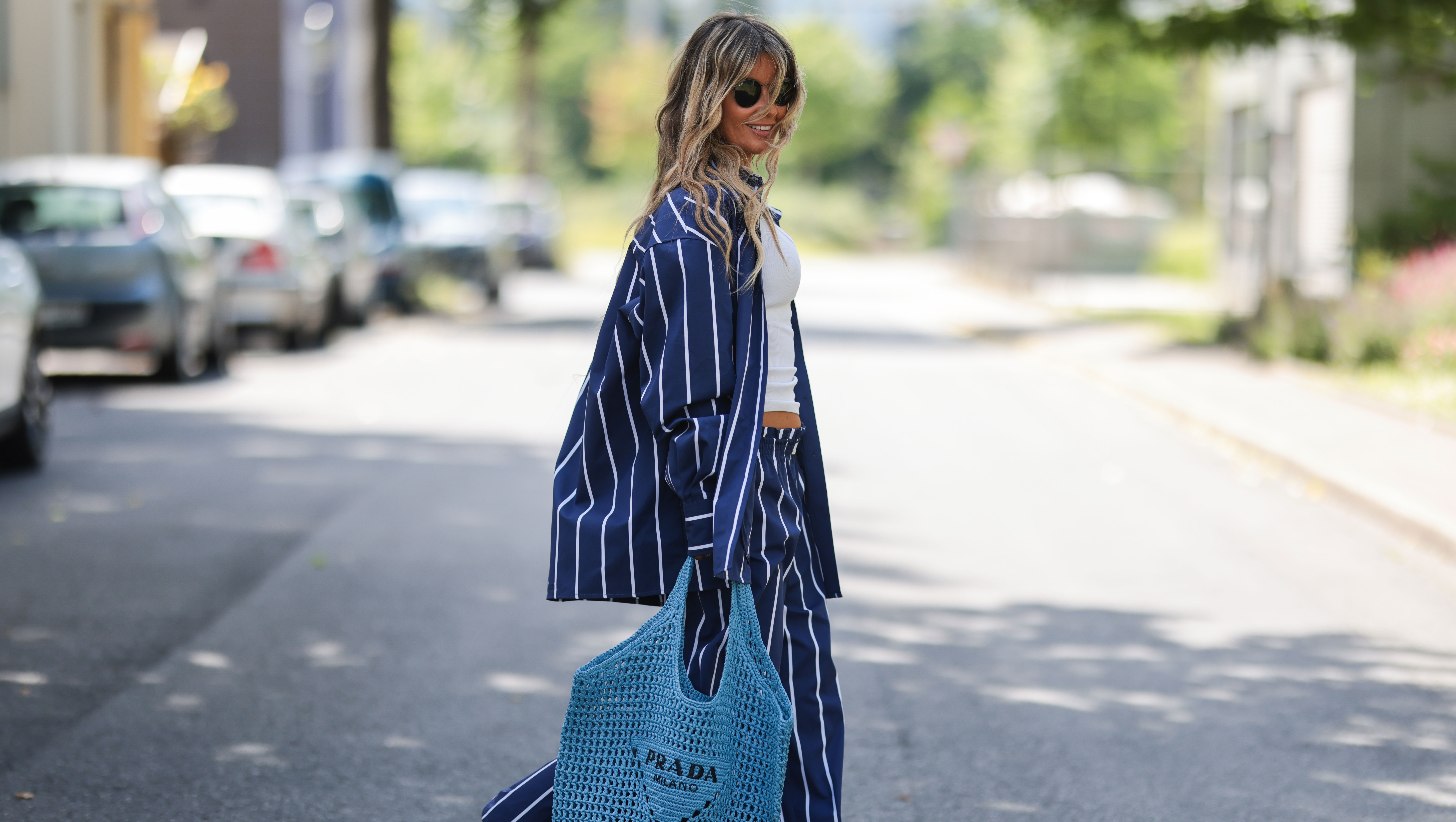 DUSSELDORF, GERMANY - JUNE 12: Gitta Banko seen wearing a Ray Ban sunglasses, a white tank top, a blue/white striped cotton pyjama set from Yaitte, rhinestone sandals from Aminah Abdul Jillil and a blue bast raffia tote bag from Prada on June 12, 2022 in Dusseldorf, Germany. (Photo by Jeremy Moeller/Getty Images)