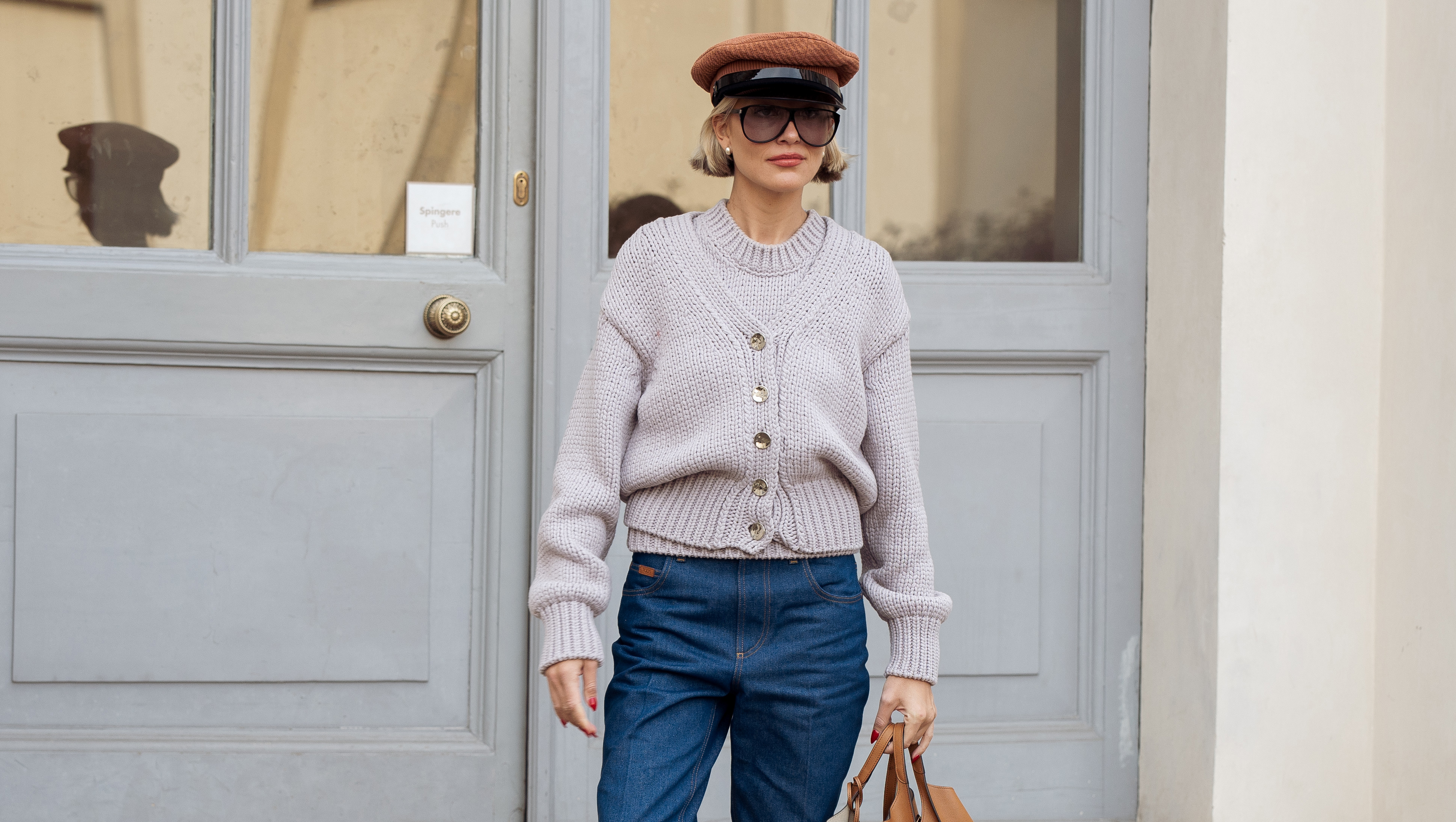 MILAN, ITALY - FEBRUARY 28: Violet Grace Atkinson wears blue jeans, pale purple sweater, brown leather bag and brown Prada hat outside the TOD's fashion show during the Milan Fashion Week Womenswear Fall/Winter 2025/2026 on February 28, 2025 in Milan, Italy. (Photo by Raimonda Kulikauskiene/Getty Images)