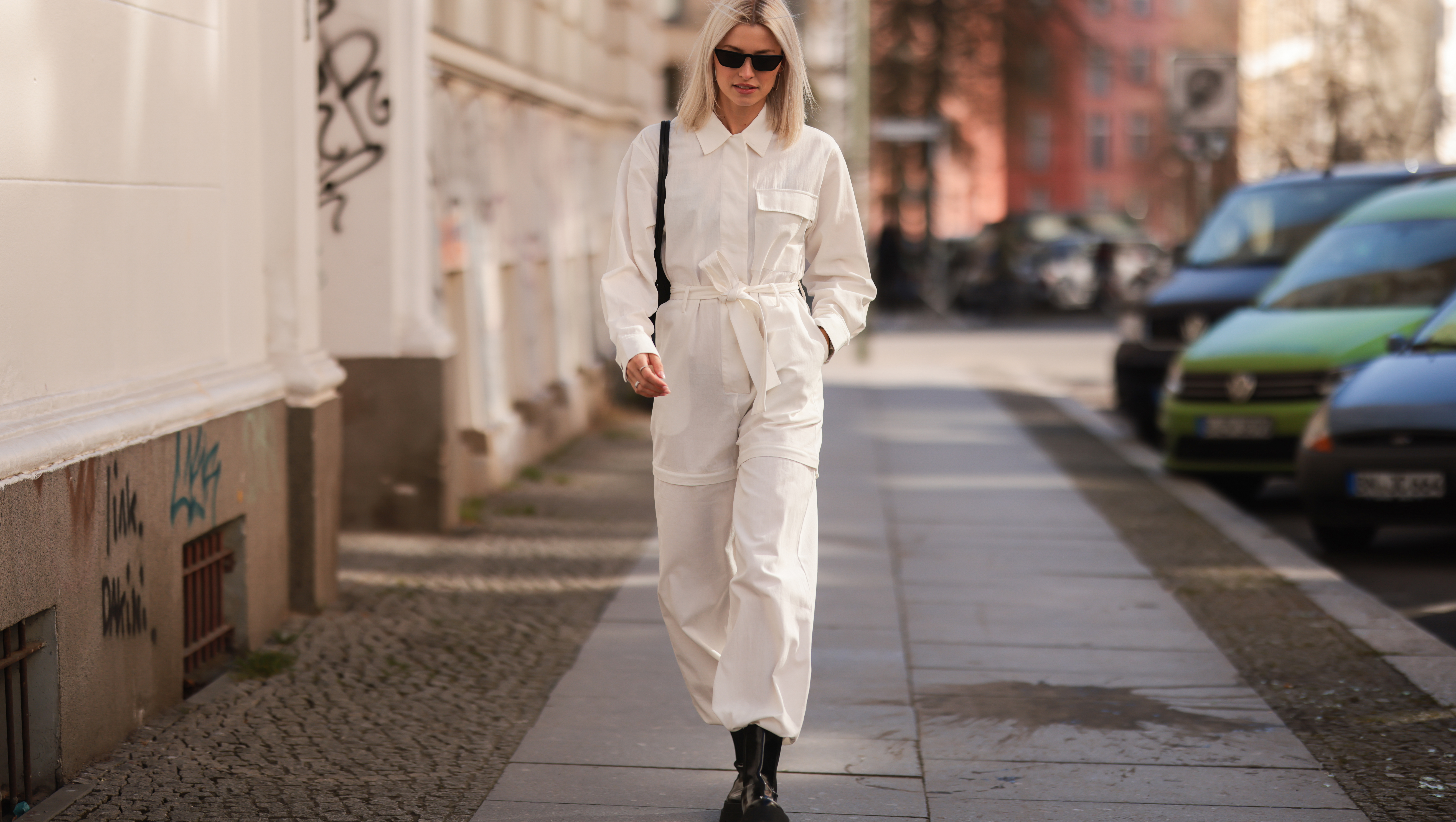 BERLIN, GERMANY - MARCH 28: Lena Gercke seen wearing a white denim overall from LeGer, a black sunglasses from Prada, silver earrings from LeGer, a black handbag from LeGer and black leather boots from LeGer on March 28, 2022 in Berlin, Germany. (Photo by Jeremy Moeller/Getty Images)