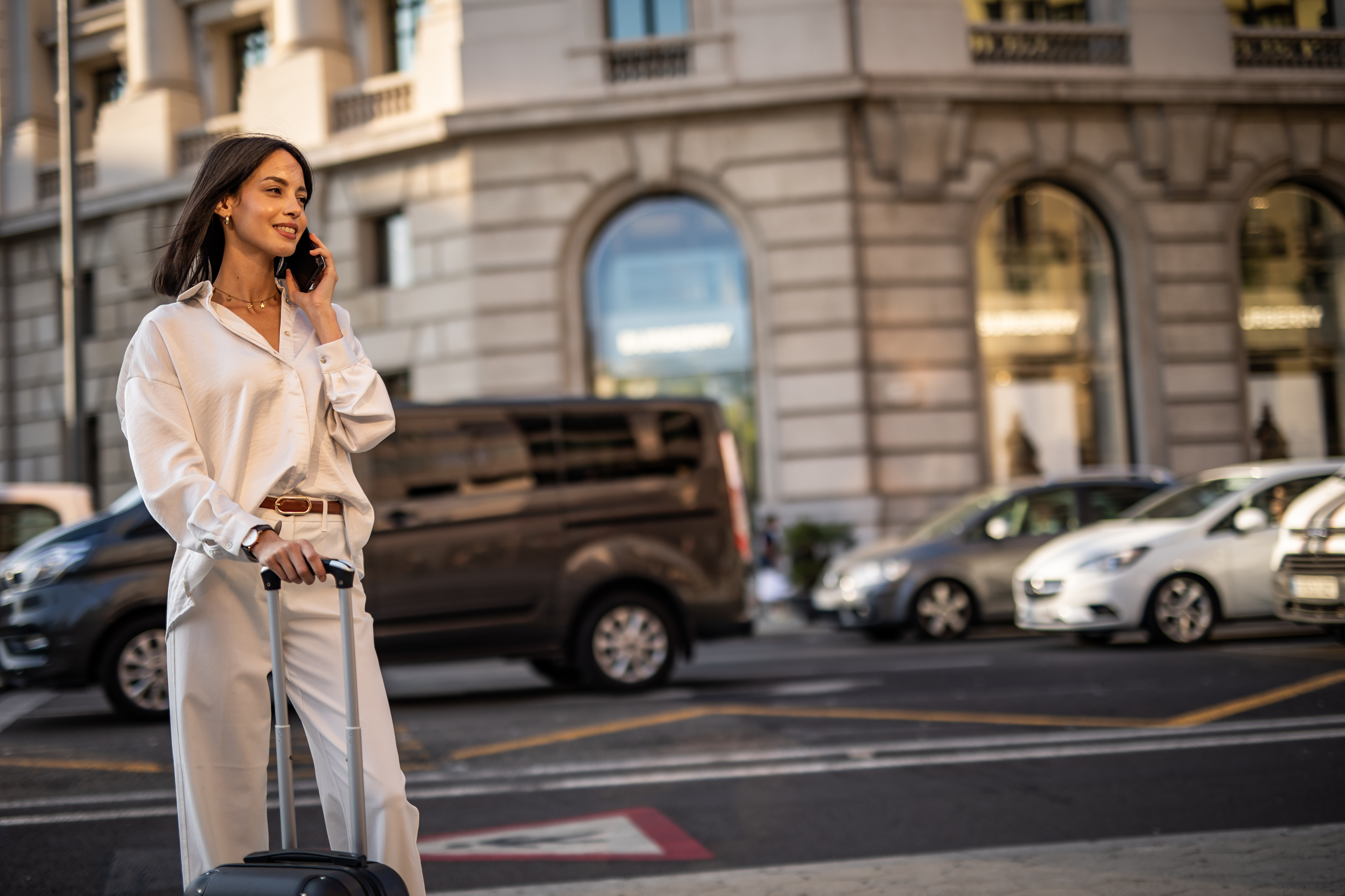 A happy pretty woman is walking on the street of Barcelona and enjoying a nice autumn day in the big city.