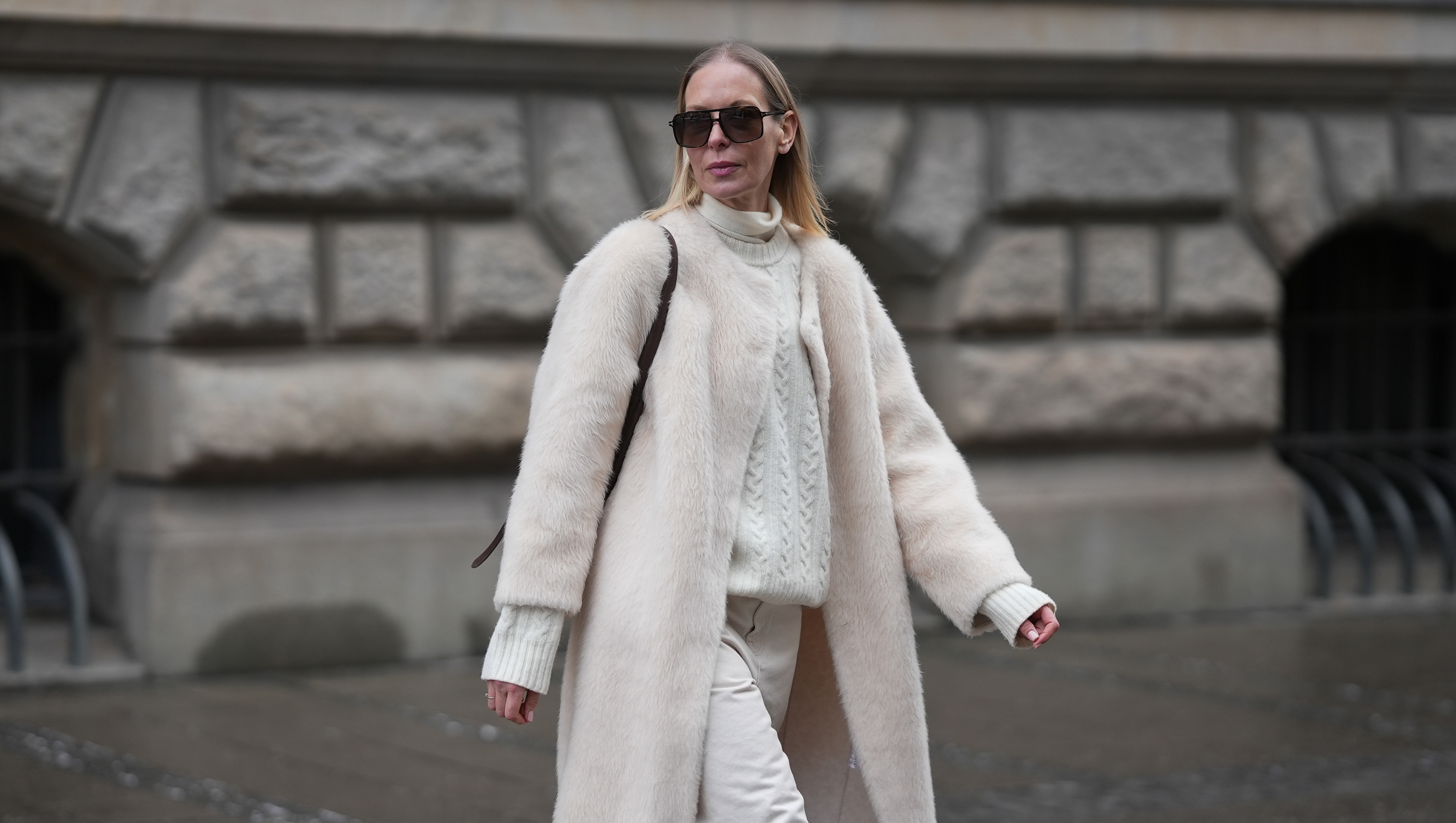 MUNICH, GERMANY - JANUARY 8: Mirja Klein is seen wearing a ‚ÄúNora brushed wool coat‚Äù in a cloud dancer tone with a straight silhouette, clean open front and subtle texture from Marcella London; a cream turtleneck knit sweater with a cable knit pattern, high ribbed collar and fitted cuffs in a cloud dancer shade from Massimo Dutti; off white straight leg Jeans with a high rise and structured cotton fabric from R√≥he Frames; a brown belted bucket bag in smooth leather with a structured silhouette and top handle from Le Liffner; oversized rectangular sunglasses with a thin acetate frame, double bridge and tinted lenses from Tom Ford; her long blond straight hair is worn loose and parted in the middle on January 8, 2026 in Munich, Germany. (Photo by Moritz Scholz/Getty Images)