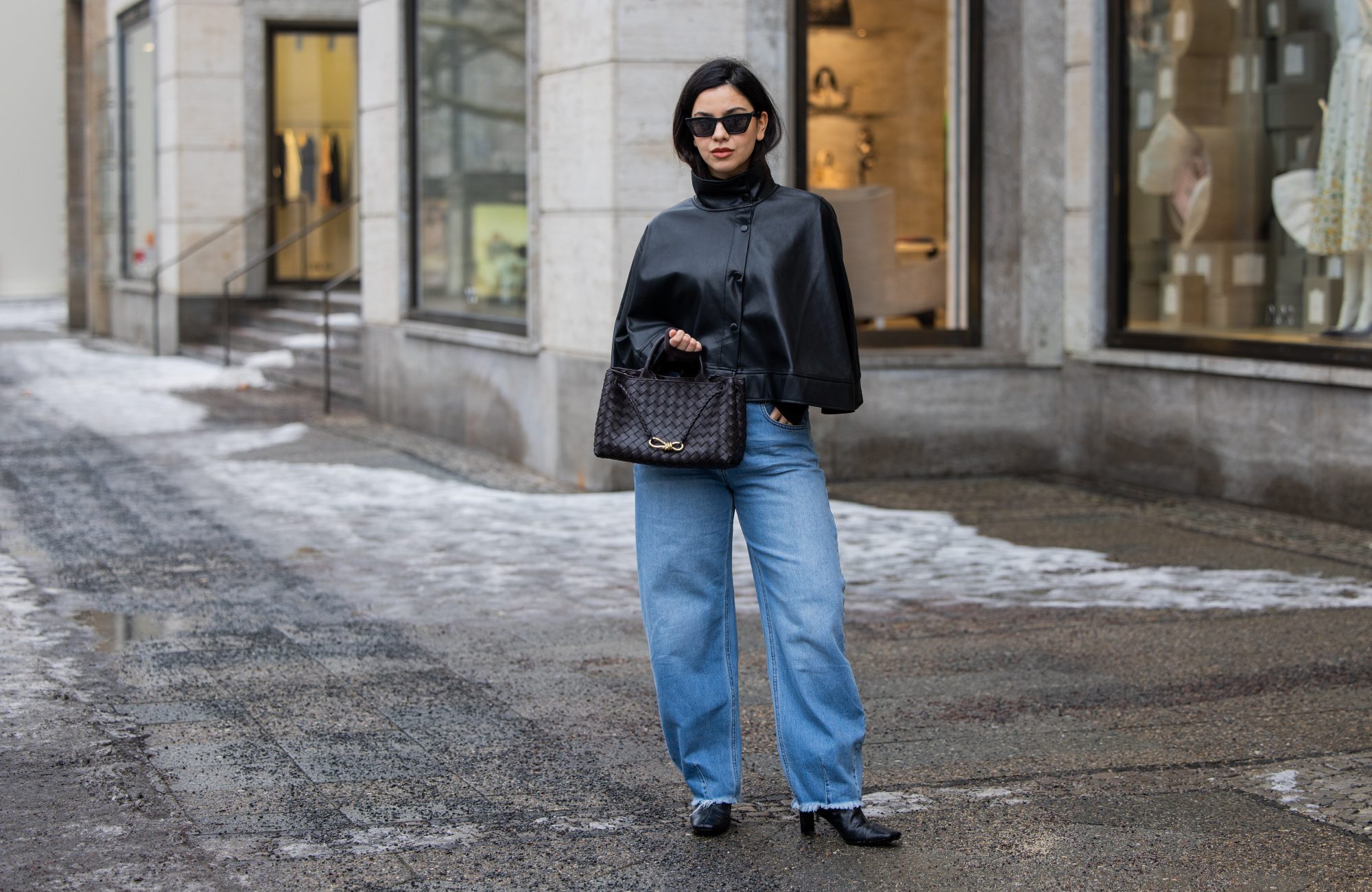 BERLIN, GERMANY - FEBRUARY 10: Bella Emar wears Gina Tricot black leather Cape, My essential wardrobe ripped jeans, flattered boots, black Bottega Veneta bag on February 10, 2026 in Berlin, Germany. (Photo by Christian Vierig/Getty Images)