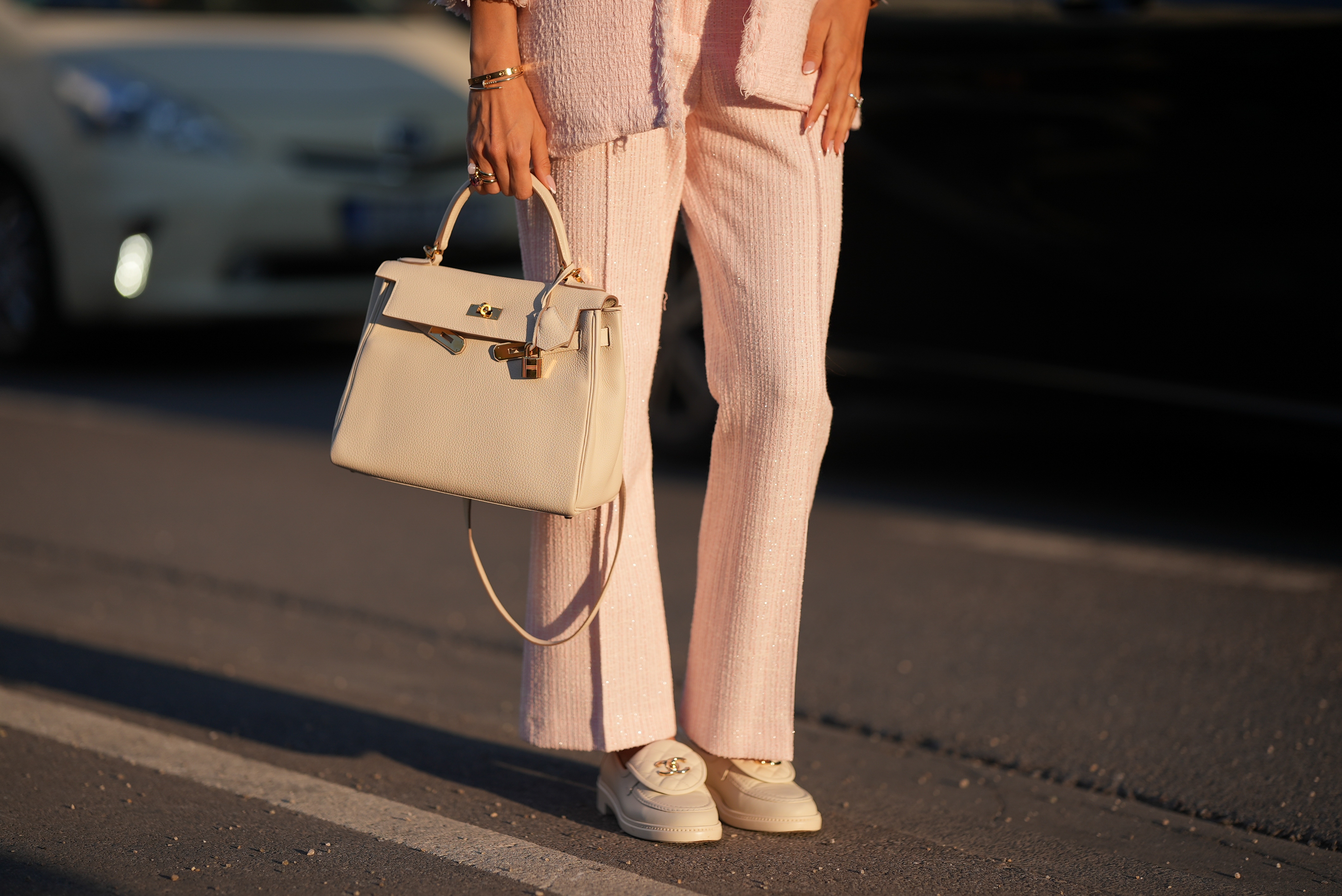 Shanice Messina is seen wearing a pink cropped marlene boucl&eacute; pants from Zara, a pink boucl&eacute; box jacket from Zara, a pair of leather moccasins in ivory with golden logo detail from Chanel, a white Kelly bag with golden details from Herm&egrave;s, stacked rings with gemstones from Pomellato, a golden Just en Clou and LOVE bracelet from Cartier on May 11, 2025 in Munich, Germany.