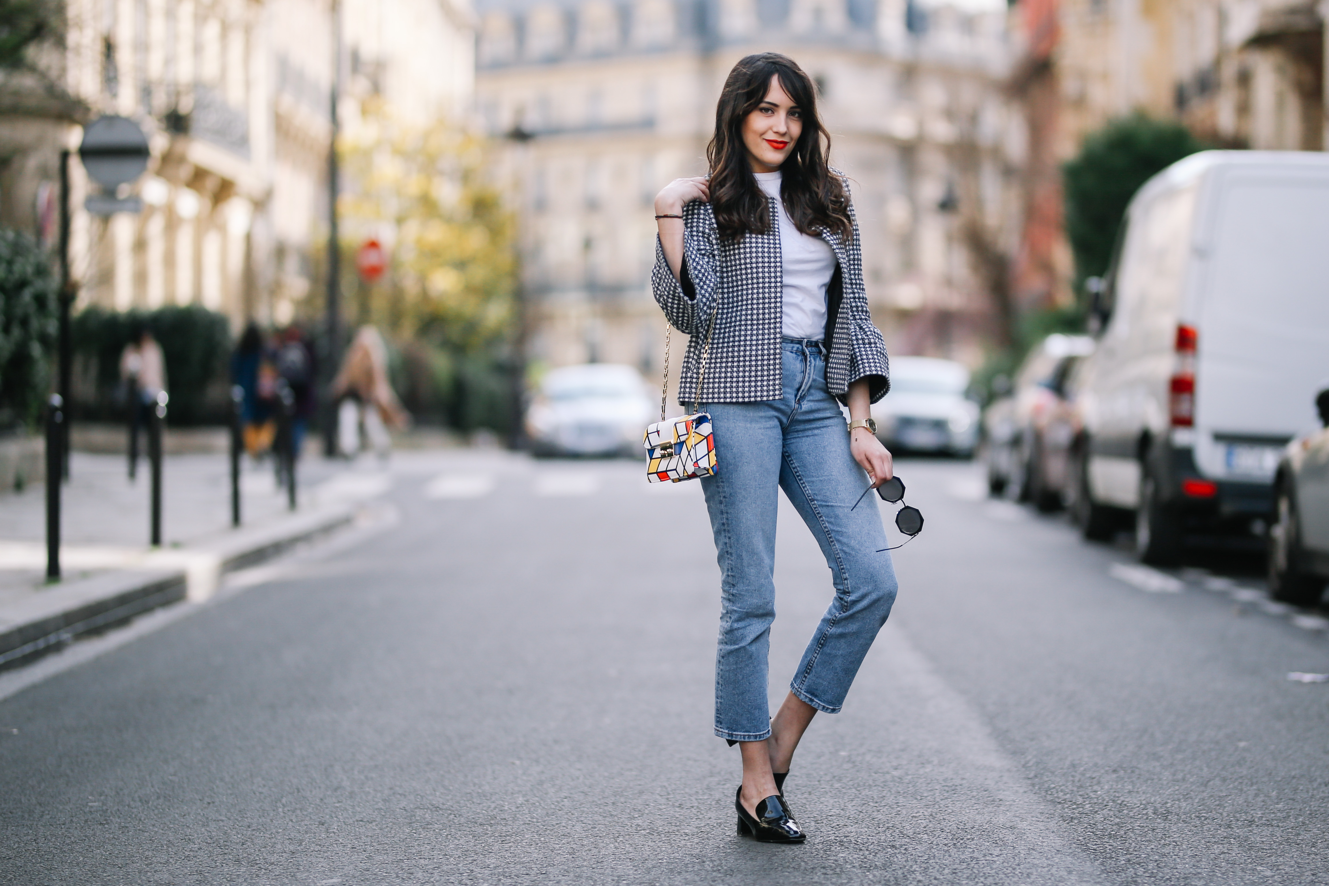 PARIS, FRANCE - MARCH 11: Sarah Benziane, fashion blogger, wears a Zara tweed checked jacket, a Zara white t-shirt, an Atelier Caesars multicolor bag, Newlook cropped blue denim jeans, and Newlook black shoes, on March 11, 2017 in Paris, France. (Photo by Edward Berthelot/Getty Images)