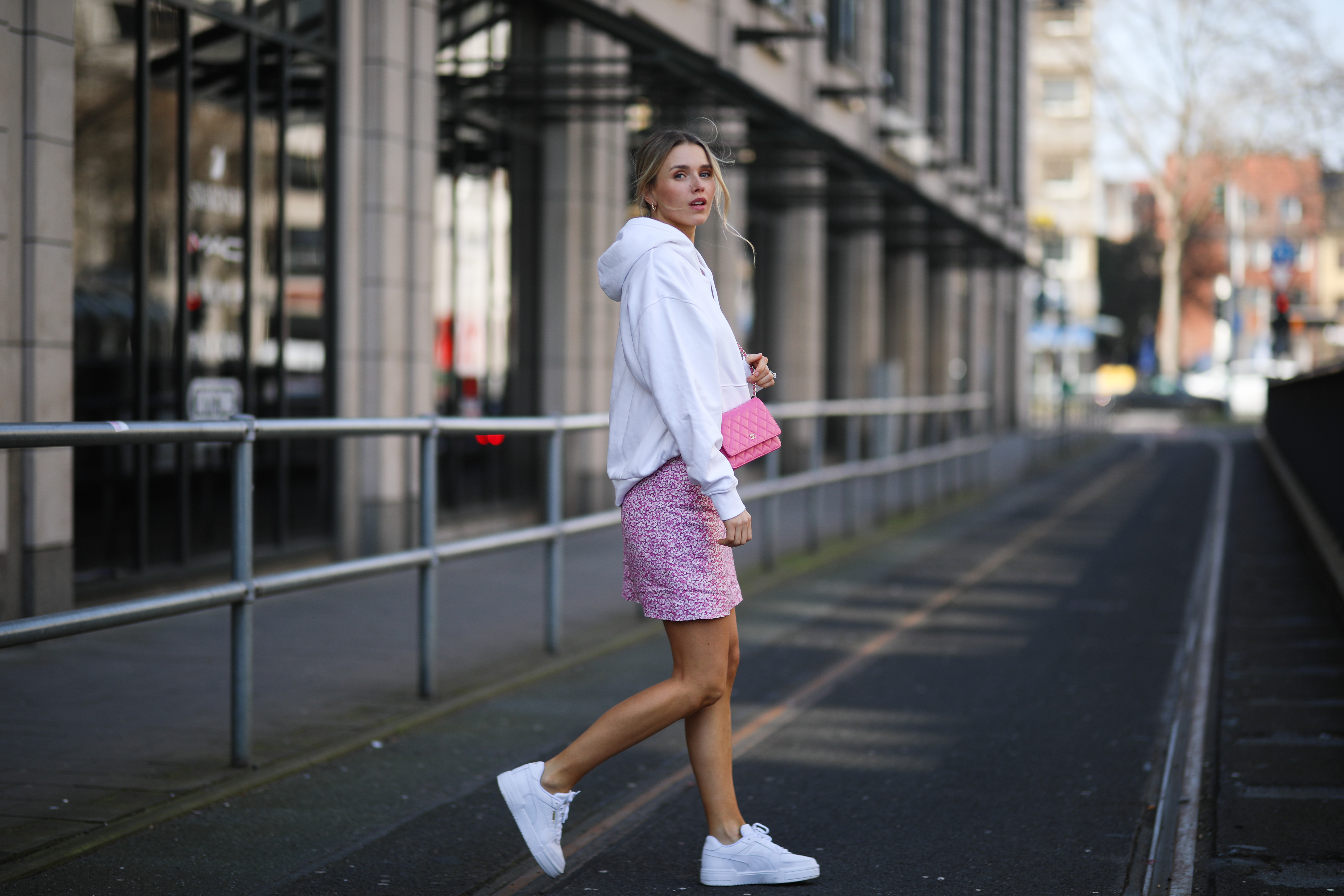 Scarlett Gartmann wearing white Weekday sweater, pink & other stories mini skirt, pink Chanel Wallet on Chain bag and Puma sneakers on March 24, 2021 in Dusseldorf, Germany.