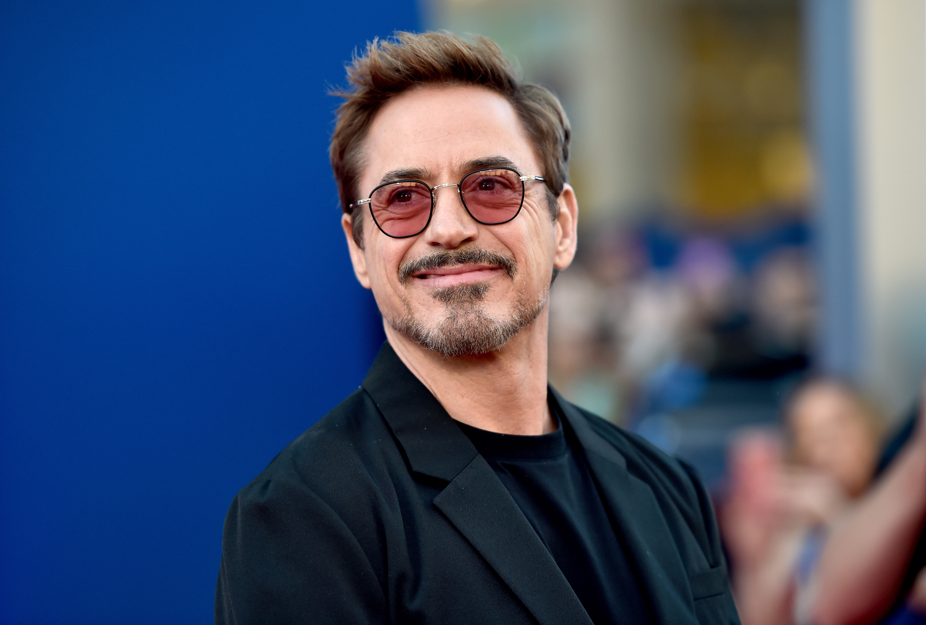 Robert Downey Jr. smirking on a red carpet.