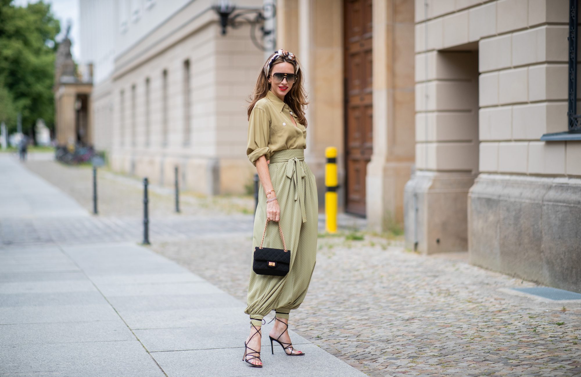 BERLIN, GERMANY - JULY 02: Alexandra Lapp is seen wearing vintage harem pants, a vintage silk blouse, Gucci foulard worn as a headband, Céline Audrey sunglasses, long Chanel earrings, black Chanel tweed bag 2.55, and black Gianvito Rossi Medea sandals during Berlin Fashion Week on July 02, 2019 in Berlin, Germany. (Photo by Christian Vierig/Getty Images)