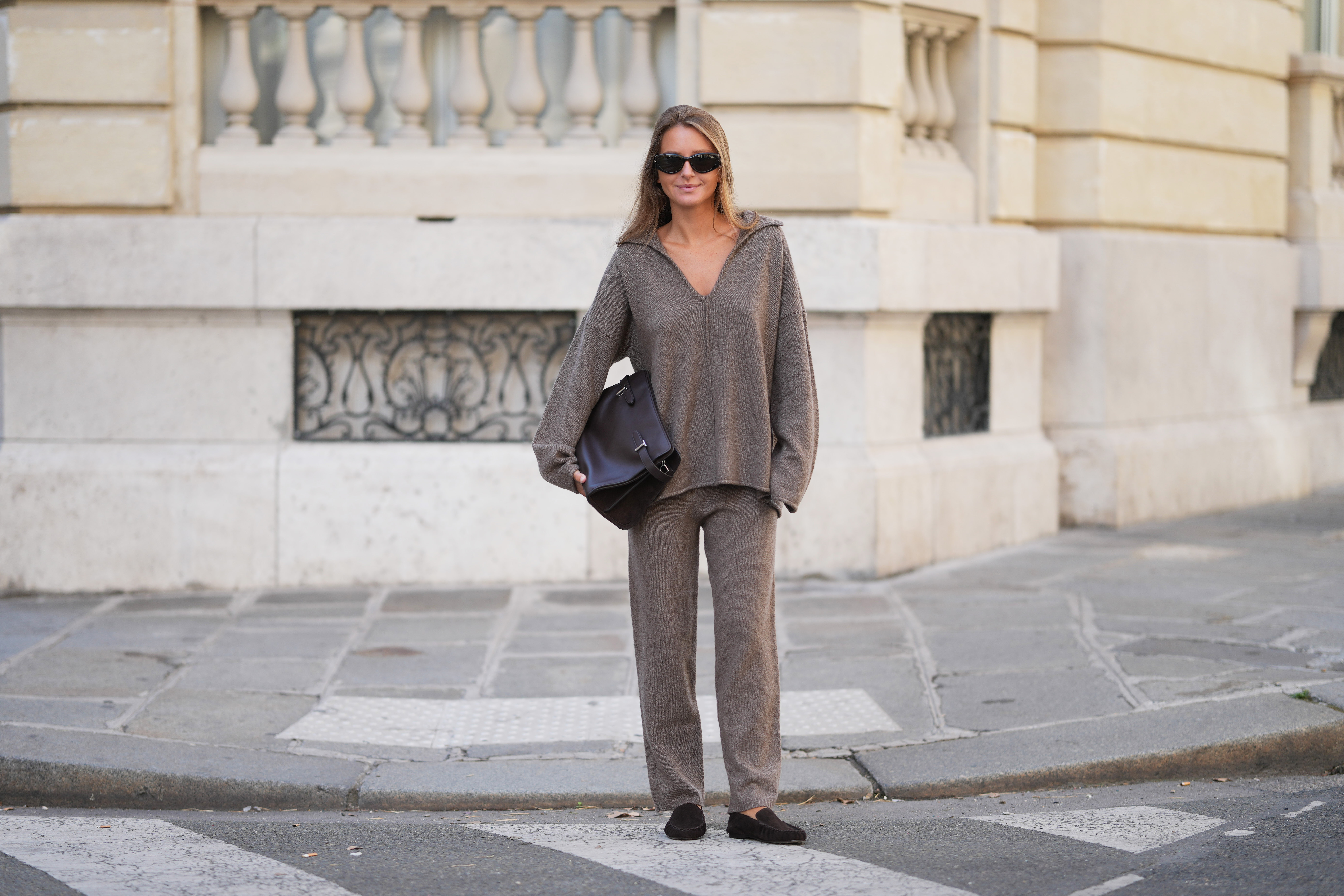 PARIS, FRANCE - SEPTEMBER 07: Diane Batoukina wears brown straight long hair, sunglasses, a By Aylin Koenig cashmere brown / beige suit made of an oversized pullover, matching beige cashmere pants, a dark brown large leather bag by Le Tanneur, brown suede loafers shoes by Flattered, during a street style fashion photo session, on September 07, 2026 in Paris, France. (Photo by Edward Berthelot/Getty Images)