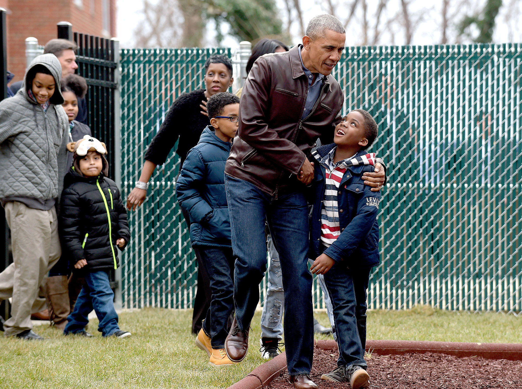 President Barack Obama talks with kids as he visits with them as they play on the "Malia and Sasha's Castle," the playground that the Obamas donated to the Jobs Have Priority Naylor Road Family Shelter in Washington, Monday, Jan. 16, 2017.